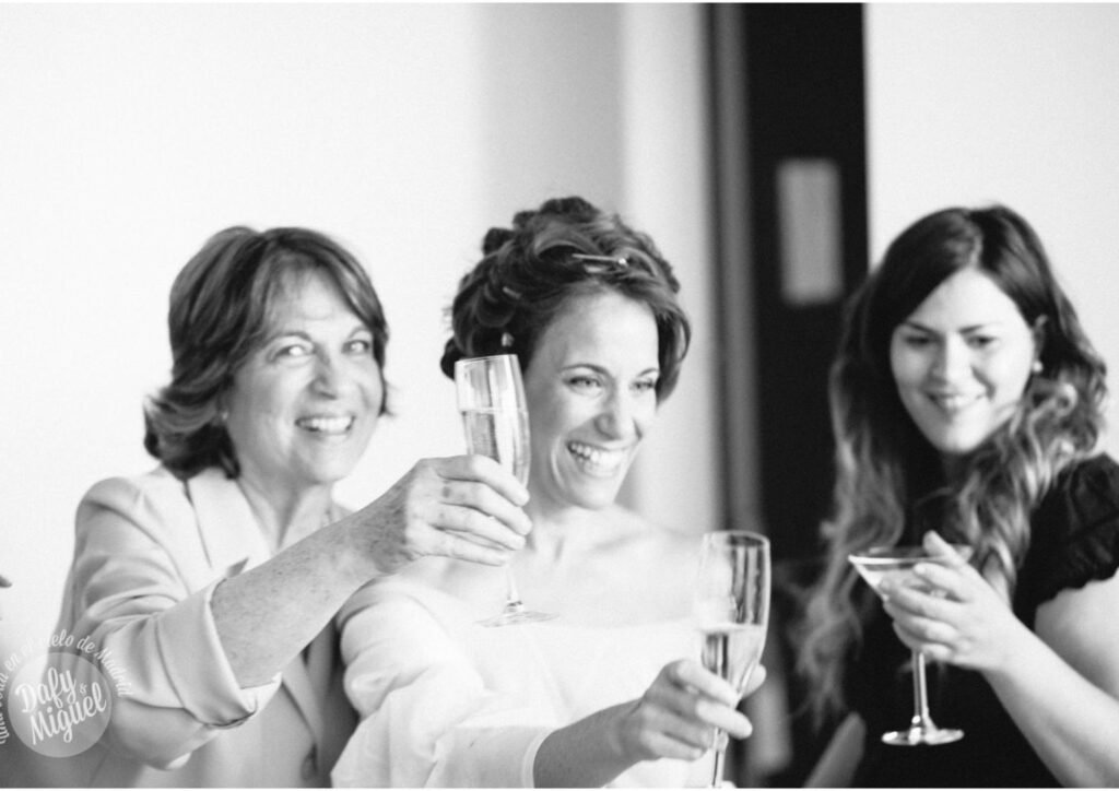 Novia con peinado nupcial y maquillaje profesional celebrando su boda con sus acompañantes en Chamberí, Madrid.
